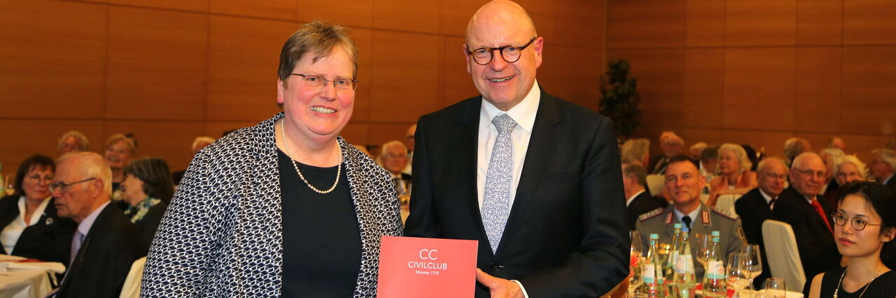 Präsidentin Michaela Heuer überreicht Oberbürgermeister Markus Lewe die Jubiläumsschrift