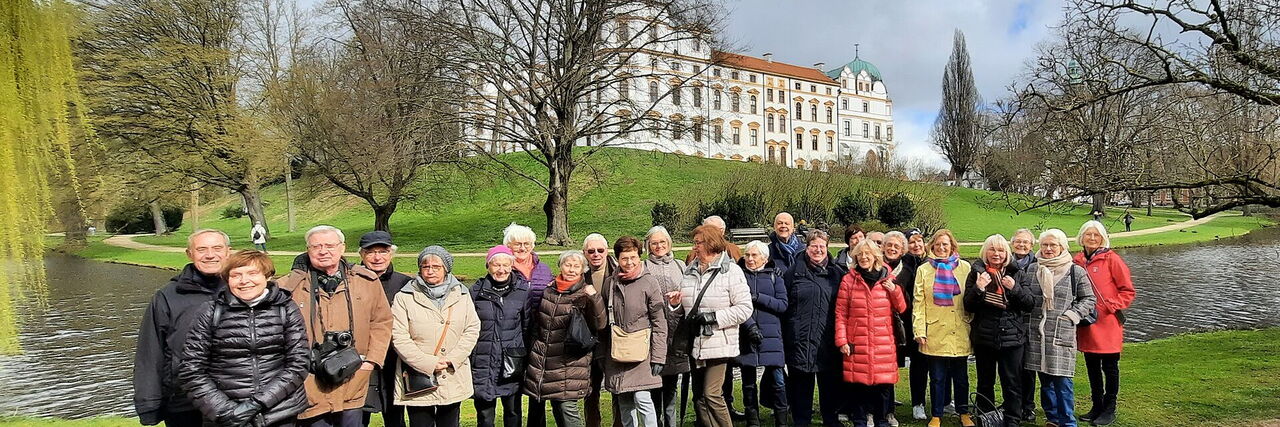 Reisegruppe im Schlosspark vor dem Schloss Celle