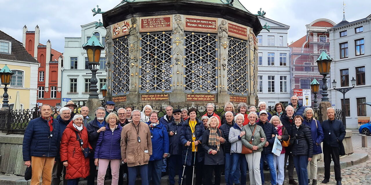 Reisegruppe vor der Wasserkunst auf dem Marktplatz in Wismar