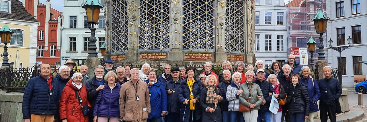 Reisegruppe vor der Wasserkunst auf dem Marktplatz in Wismar